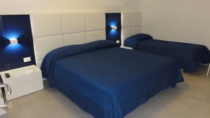Una habitación de hotel con dos camas, un tocador blanco y una mesita de noche.