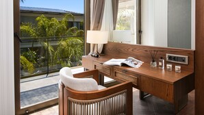 A modern hotel room with a large window, a wooden desk, a chair, and a large mirror. - Genesis Hotel (Cesme)