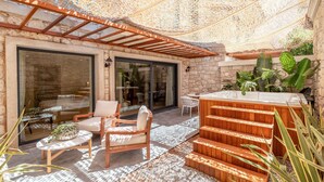 A patio with outdoor seating, a hot tub, and a pergola providing shade. - Genesis Hotel (Cesme)