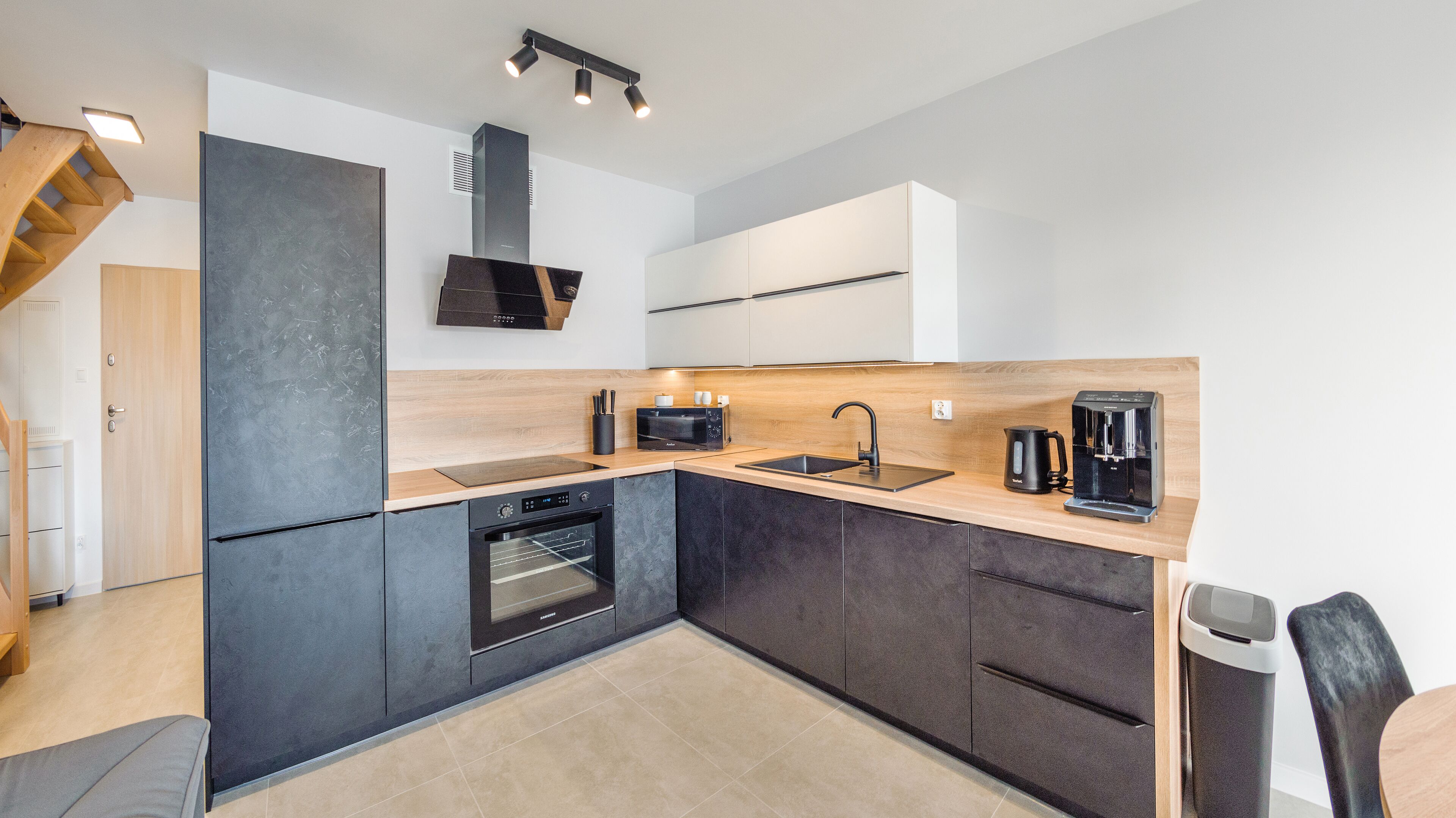A modern kitchen with a built-in oven, microwave, and coffee maker.