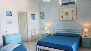 Een slaapkamer met een bed, twee nachtkastjes, een stoel en een kaptafel.