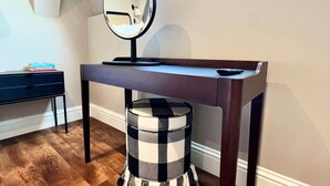A room with a desk, a round mirror, and a checkered ottoman. - Redland Suites - Apartment 7 (Redland)
