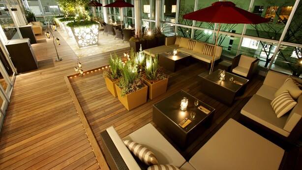 An indoor patio area with wooden flooring, multiple seating arrangements including sofas and chairs, and potted plants. - KOKO HOTEL Kobe Sannomiya (Kobe)