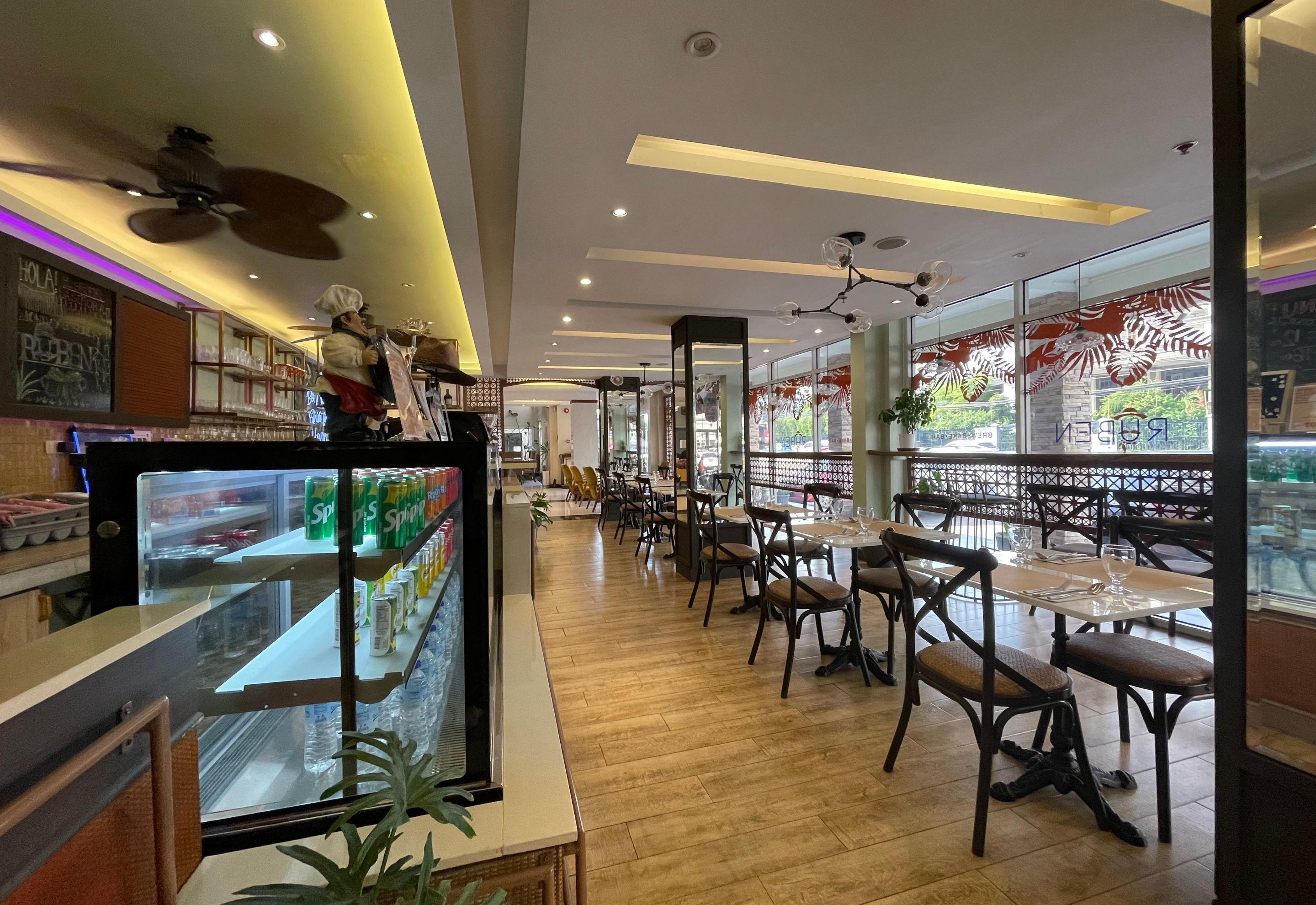 A restaurant interior with a counter, seating area, and a glass display case.