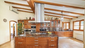 Une cuisine spacieuse avec des meubles en bois, un plan de travail en granit et un grand îlot central.