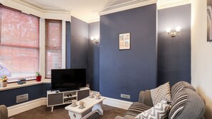 Ein Wohnzimmer mit Fernseher, Sofa und Couchtisch.