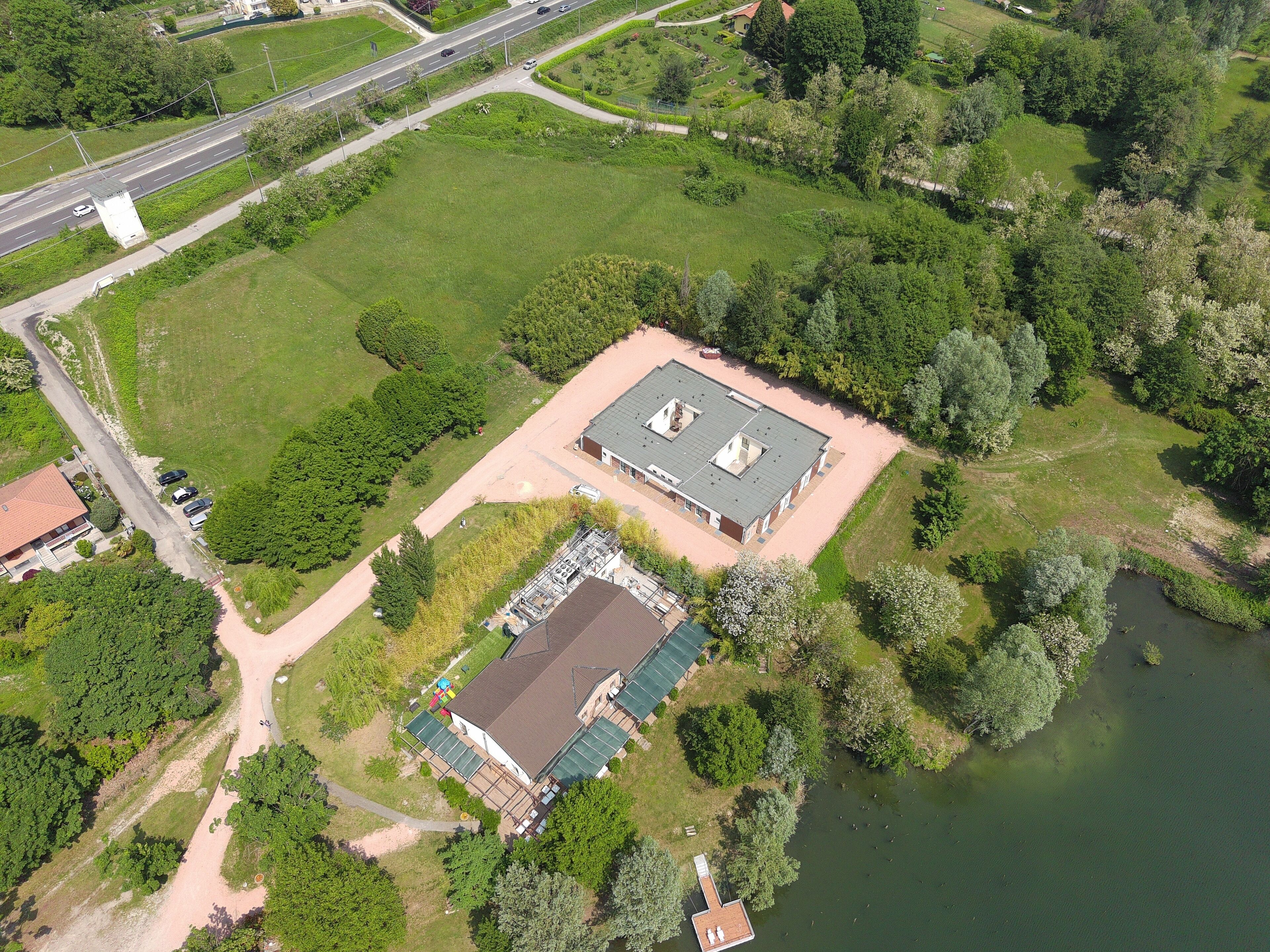 Luchtbeeld van een pand met een groot gebouw, een kleiner gebouw ernaast en een waterpartij.