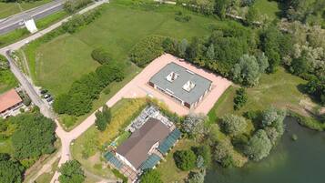 Luchtbeeld van een pand met een groot gebouw, een kleiner gebouw ernaast en een waterpartij.