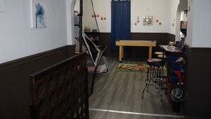 Une pièce avec un banc en bois, une table et un rideau bleu.
