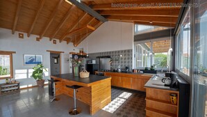 Una cocina moderna con armarios de madera, una isla central y un ventanal que proporciona luz natural.
