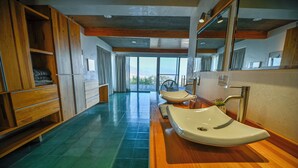 Un baño moderno con armarios de madera, un espejo grande y vistas al exterior.