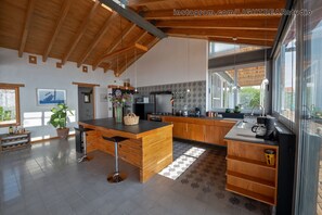 Una cocina moderna con armarios de madera, una isla central y un ventanal que proporciona luz natural.