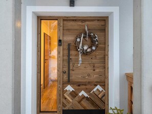 A wooden door with a decorative wreath and a geometric pattern below it. - Apartment "S'HOAMELIGE" - House Wiederkehr (Schladming)