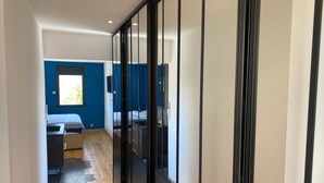 Ein Flur mit einem Bett, einem Schreibtisch und einem Kleiderschrank.