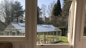 Une pièce donnant sur une serre, vue à travers une fenêtre.