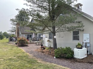 A house with a patio, outdoor furniture, and a covered grill area.