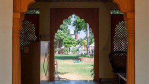 An archway leading to a courtyard with patterned flooring and a view of greenery. - Ranthambore Tiger Resort by Park Tree (Sawai Madhopur)