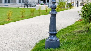 A traditional street lamp in front of a white building with shutters and a red-tiled roof. - Maison Qualisterra - Chambre d'Hôtes (Bar-sur-Aube)