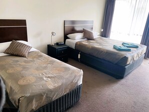 Habitación ejecutiva con 2 camas individuales | Espacio para trabajar con laptop y tabla de planchar con plancha