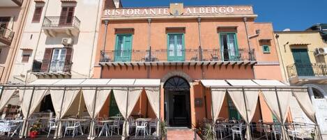 A restaurant named Ristorante Albergo with outdoor seating and a covered entrance.