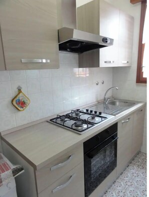 Refrigerador, placa de cocina, utensilios de cocina, mesa de comedor