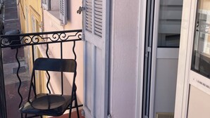 A balcony with a metal chair, a sliding glass door, and a view of a street with buildings. - T2 41 m2 CANNES bas SUQUET with parking, near beach and town center (Cannes)