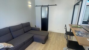 A modern living space with a sectional sofa, a dining table with chairs, a hanging pendant light, and a sliding door. - T2 41 m2 CANNES bas SUQUET with parking, near beach and town center (Cannes)