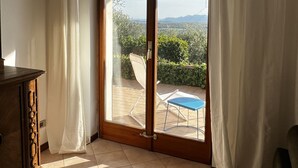 A room with a sliding glass door leading to an outdoor patio with a table and chairs. - Private garden, tranquility and privacy (San Michele-montecchio)