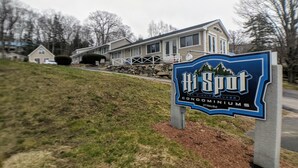 A sign for Hi Spot Condominiums with a view of a house in the background. - Hi Spot Studio with shared beach on Winnipesaukee! (Laconia)