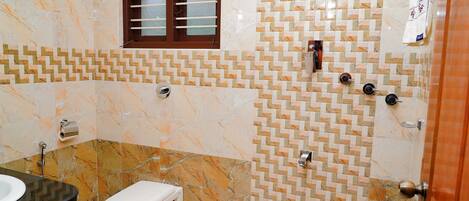 Un baño con inodoro, lavabo y zona de ducha.