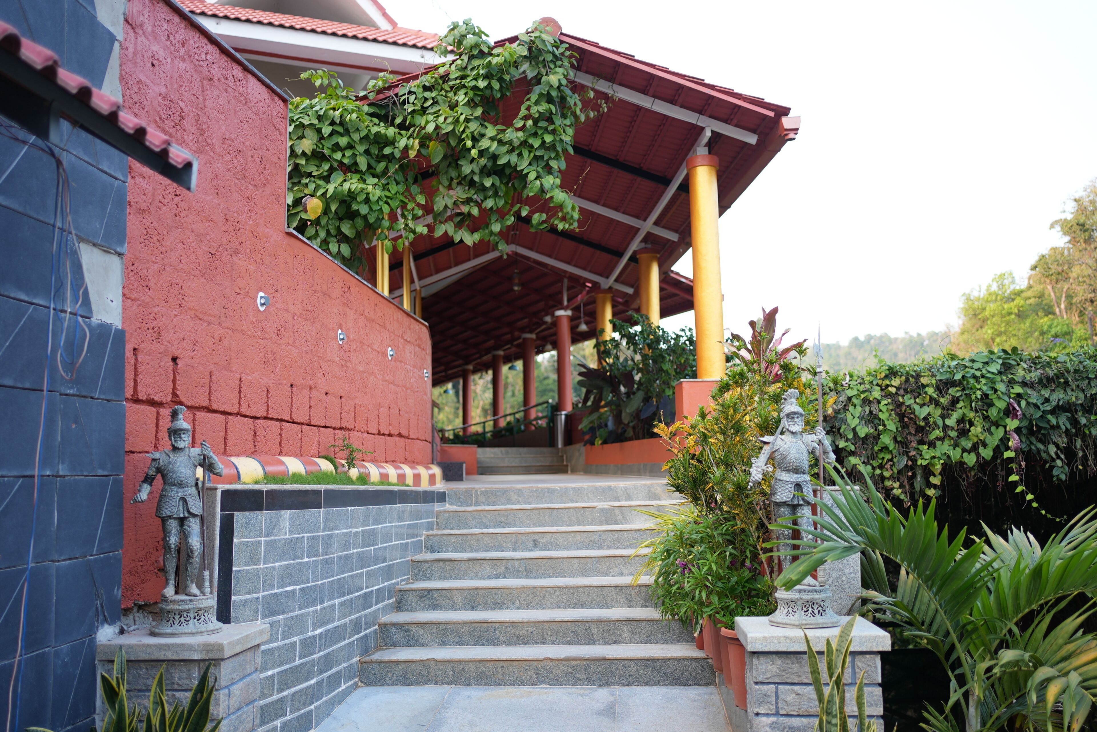 A building with a red exterior, a covered entrance, and steps leading up to it.