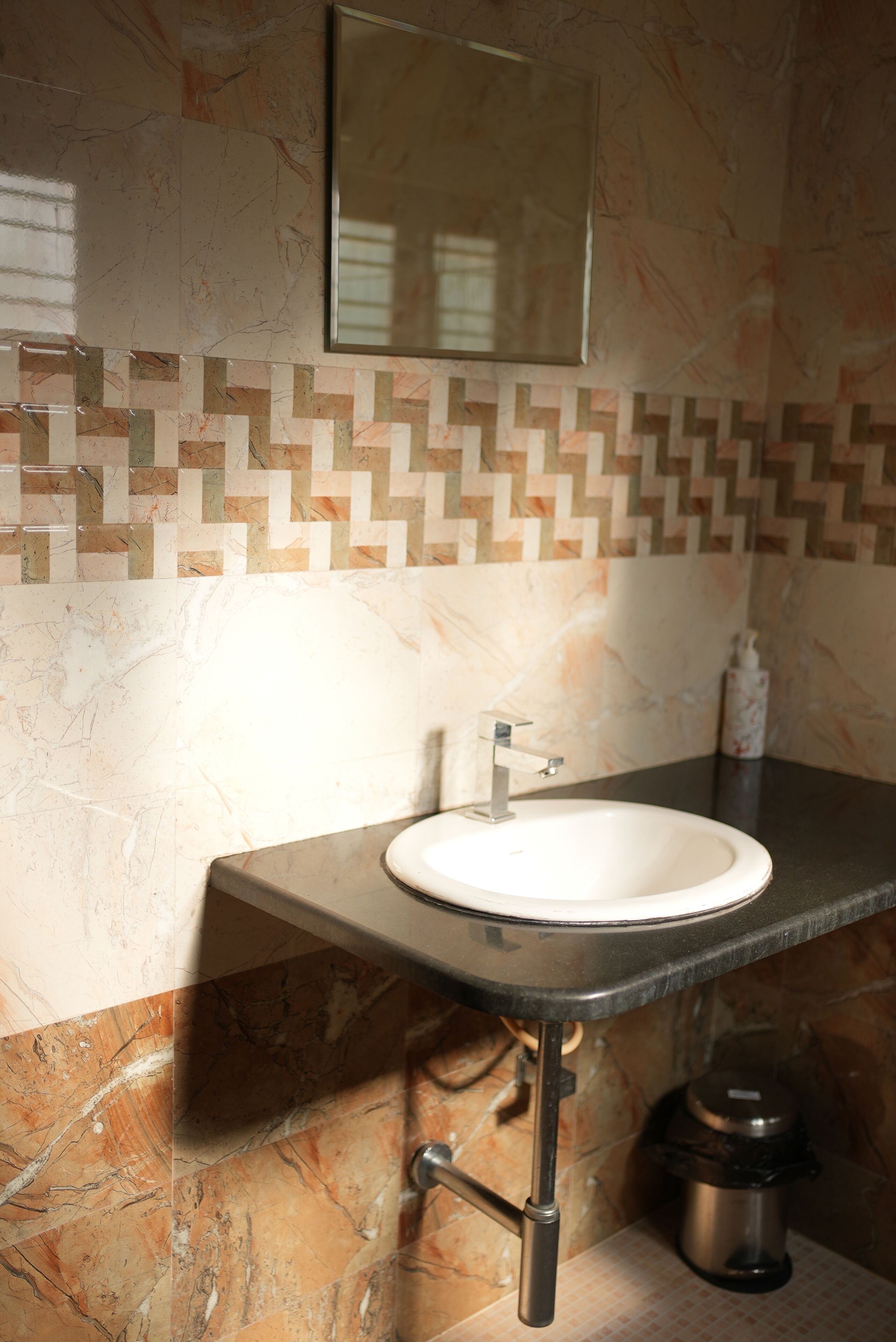 A bathroom with a sink, mirror, and tiled backsplash.
