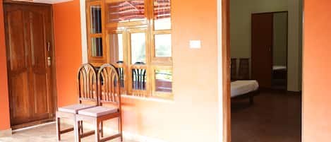 Una habitación con una cama, una puerta de madera y una ventana con vistas.