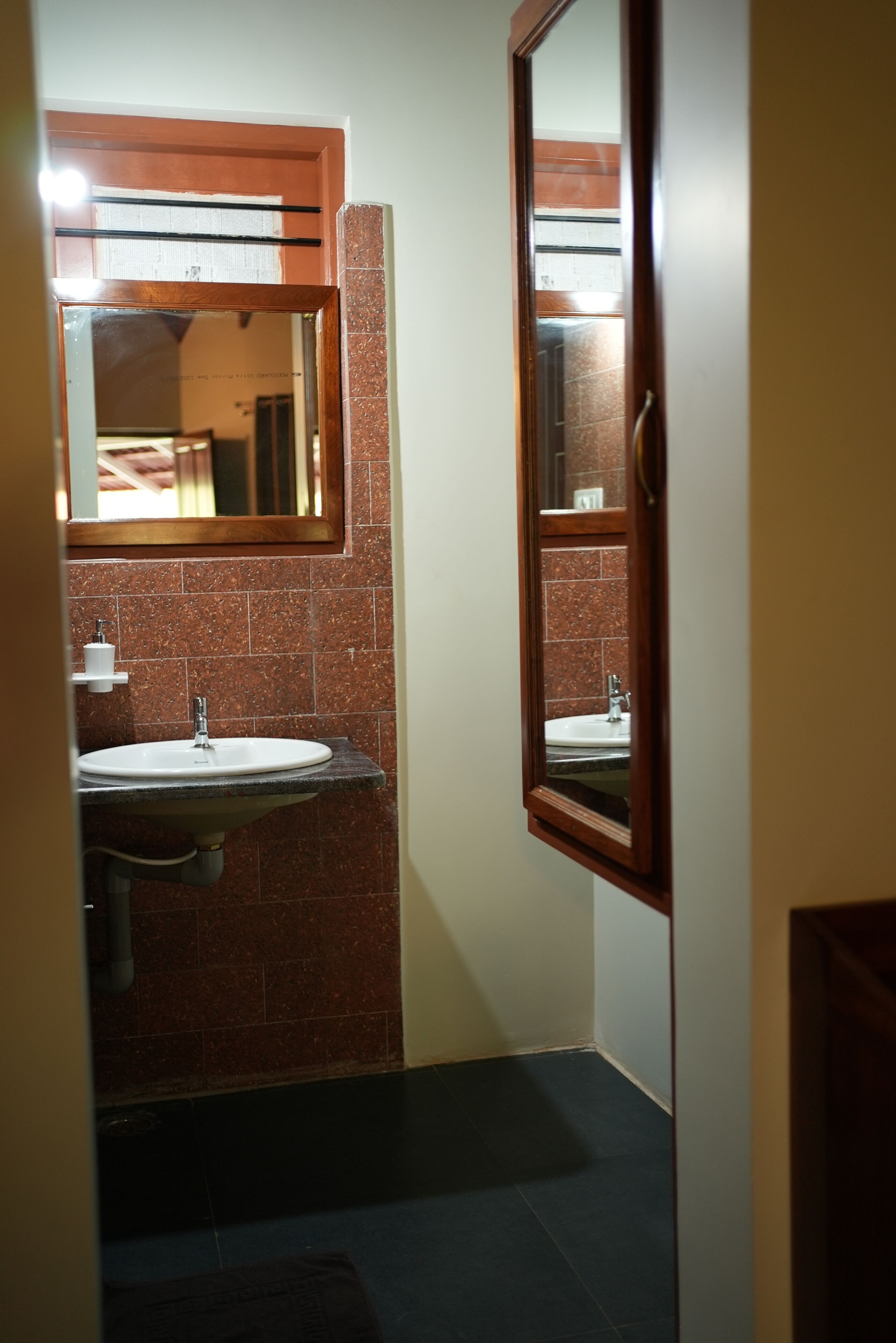 A bathroom with a sink, mirror, and towel rack.