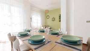 A dining area with a long table set for four, featuring teal plates and clear glasses. - Il Borgo Apartments A1 - Sv-d600-bove3ata (Finale Ligure)
