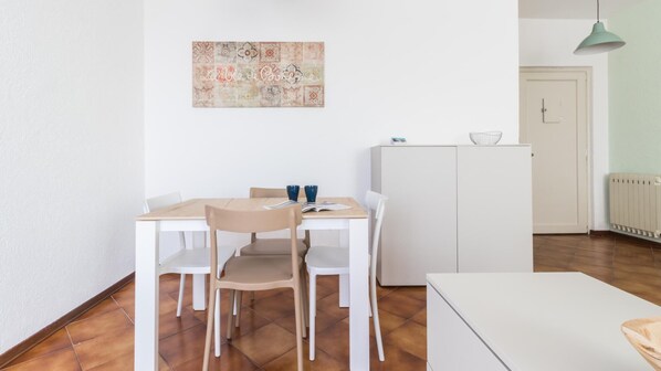 A dining area with a wooden table and chairs, a white cabinet, and a radiator.