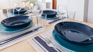 A dining table set with blue plates, clear glasses, and a fork. - Il Borgo Apartments B2 - Sv-d600-bove3ftb (Finale Ligure)