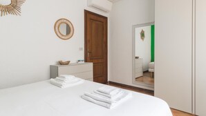 A bedroom with a bed, a wooden door, a dresser, and a mirror. - Il Borgo Apartments B2 - Sv-d600-bove3ftb (Finale Ligure)