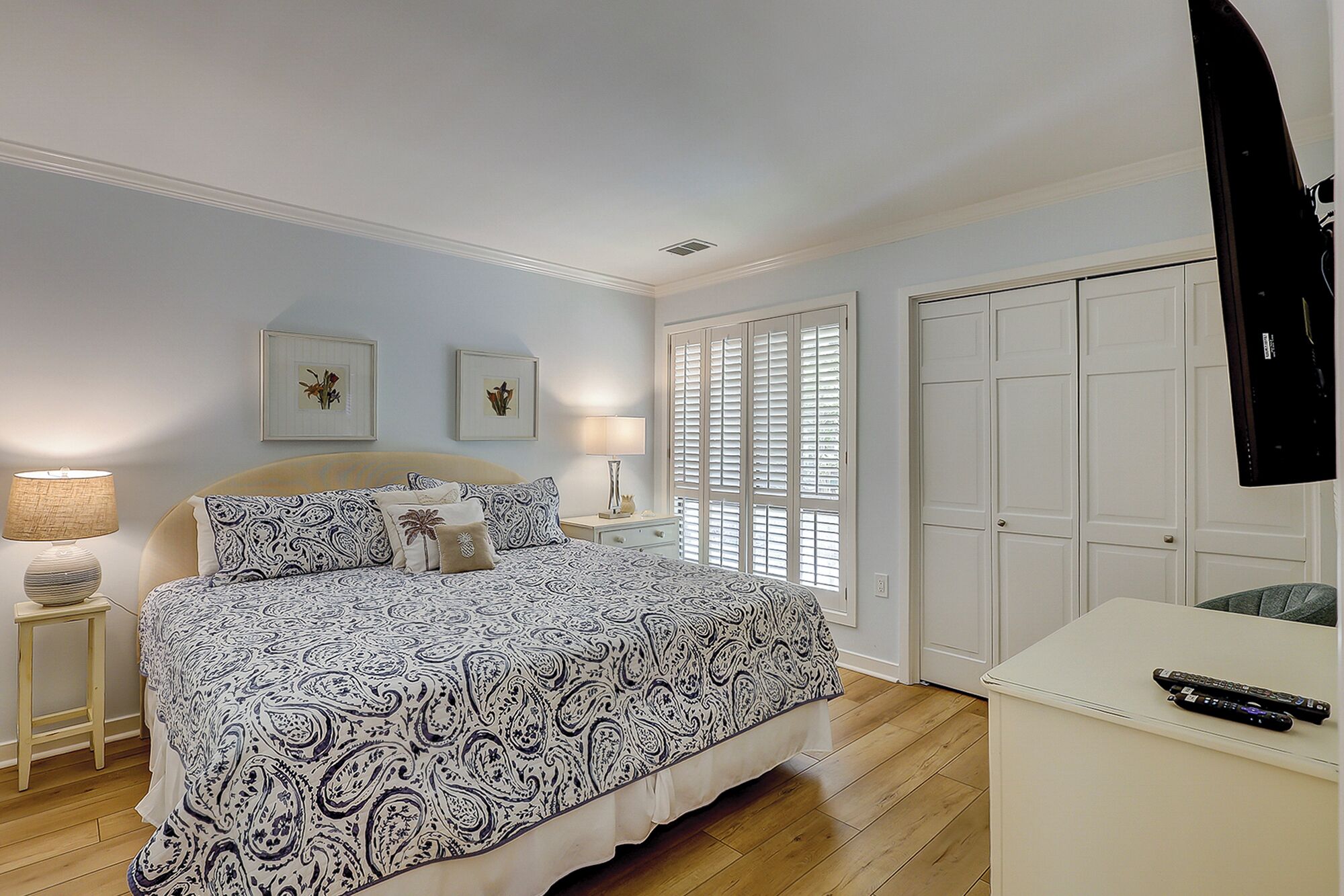 A bedroom with a bed, bedside tables, a desk, and a wardrobe.