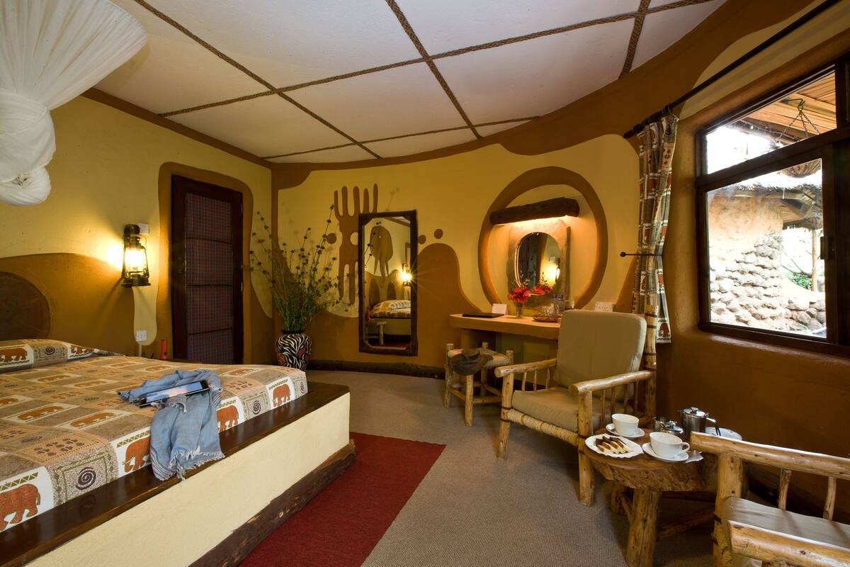 A hotel room with a bed, a desk, a chair, and a window with a view of the outside.