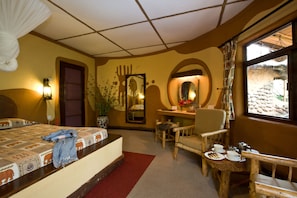 Une chambre d’hôtel équipée d’un lit, d’un bureau, d’une chaise et d’une fenêtre donnant sur l’extérieur.