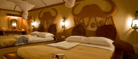 Una habitación de hotel con dos camas, un cabecero decorativo grande y una lámpara colgante.