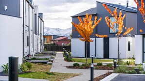 A modern building complex with a pathway leading to a gated entrance.
