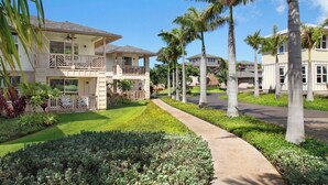A residential area with multiple two-story houses, a paved walkway, and palm trees. - Pili Mai 12L Central AC By Suite Paradise (Koloa)