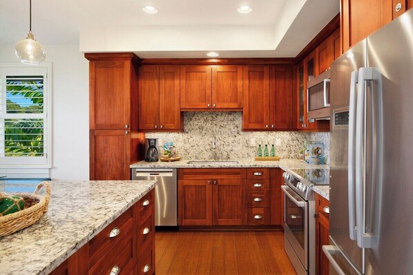 Una cocina moderna con armarios de madera, electrodomésticos de acero inoxidable y encimera de granito.
