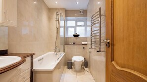 A modern bathroom with a bathtub, toilet, and shower. - The Haggerston Flats (London)