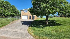 A single-story building with a garage, surrounded by a well-maintained lawn and a tree.