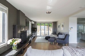 Ein modernes Wohnzimmer mit Kamin, Sofa und Fernseher.