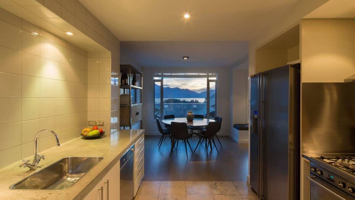 Una cucina moderna con zona pranzo, ampie finestre e vista sulle montagne.