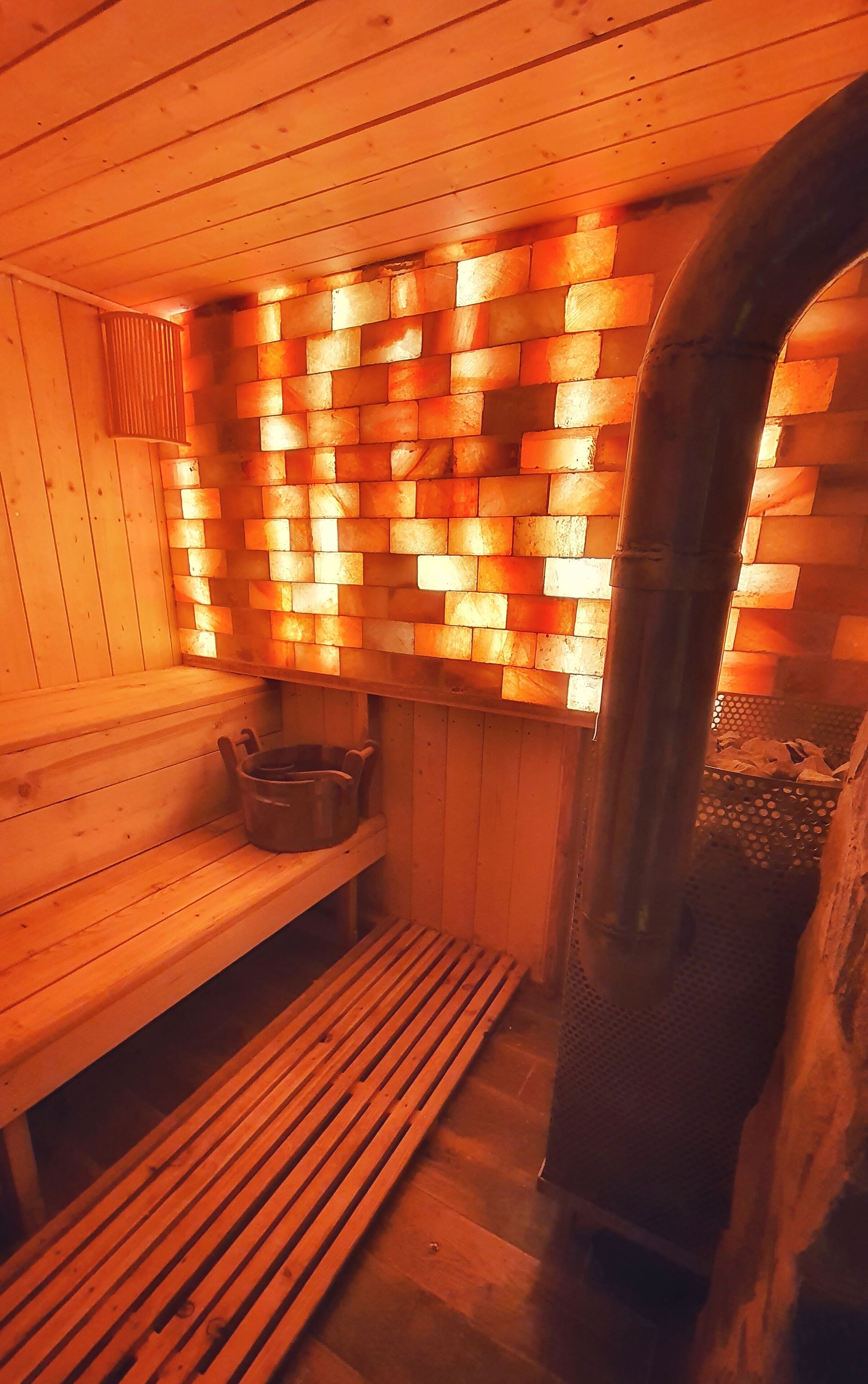 Eine Sauna mit Holzbänken und einer Ziegelwand.